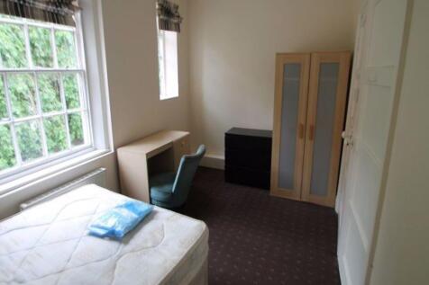 A cozy single bedroom featuring a comfortable b...