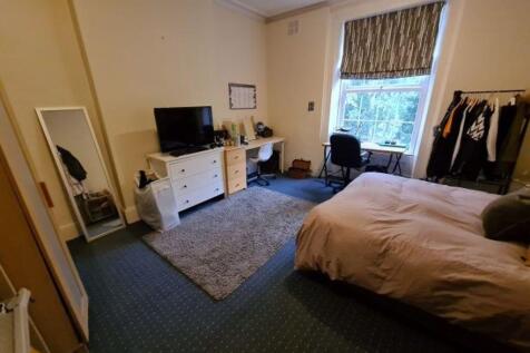 A bright and cozy bedroom featuring a comfortab...