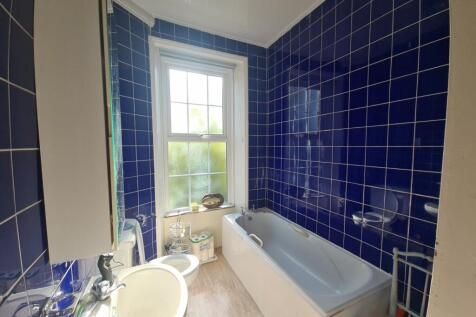 A clean, modern bathroom featuring a large bath...
