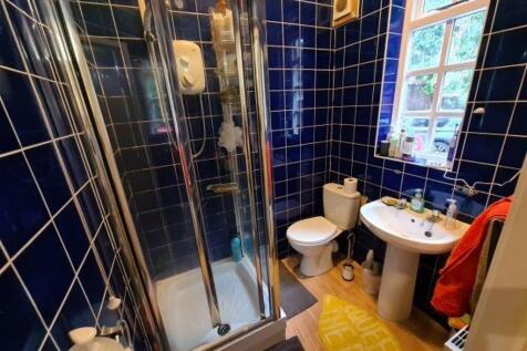 A well-maintained bathroom featuring a glass sh...