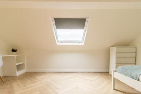 Bright and airy bedroom with a skylight window ...