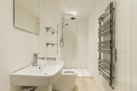 A bright and minimalist bathroom featuring a wh...