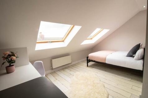 Bright and airy double bedroom with a cozy bed,...