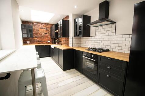 Modern kitchen with black cabinetry, white tile...