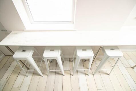 Bright and modern kitchen area featuring a long...