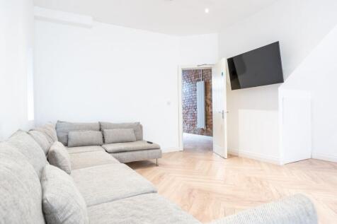 Bright and modern living room featuring a large...