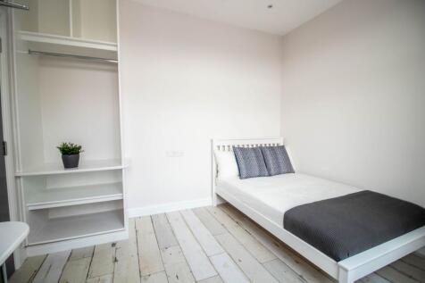 Bright and modern double bedroom featuring a wh...