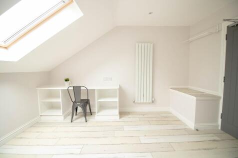 Bright, airy attic bedroom with a large skyligh...