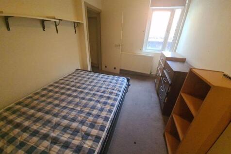 A cozy single bedroom featuring a comfortable b...