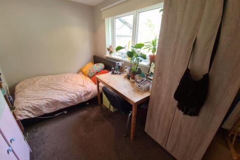 A cozy single bedroom featuring a comfortable b...