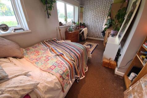 A cozy single bedroom featuring a comfortable b...