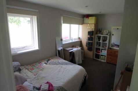 A cozy single bedroom featuring a comfortable b...