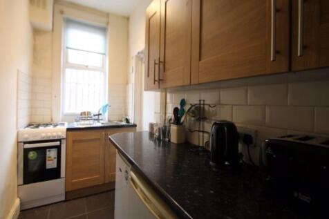 A compact and tidy kitchen featuring wooden cab...