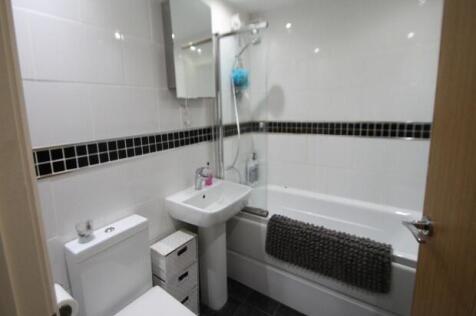 Bright and clean bathroom featuring a bathtub w...