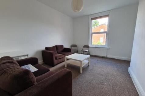 A spacious and tidy living room featuring comfo...