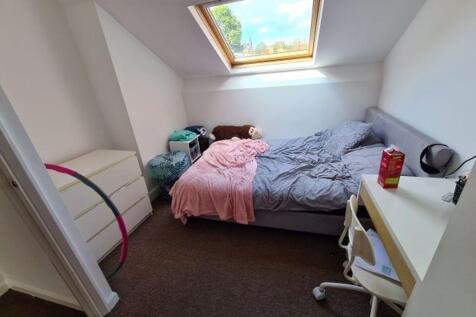 A bright and cozy master bedroom with a large w...