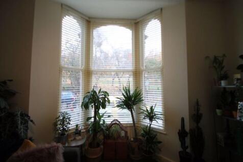 A bright and welcoming living room featuring la...