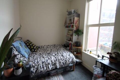 A cozy single bedroom featuring a comfortable b...