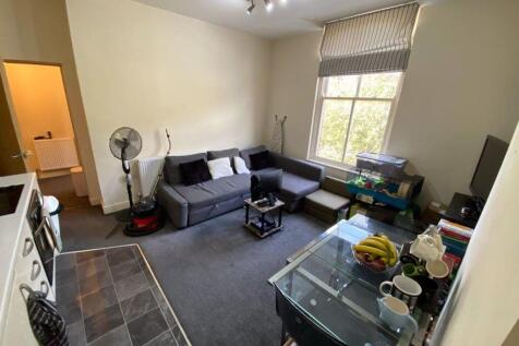 A spacious and welcoming living room with large...