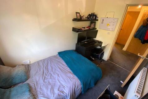 A cozy double bedroom featuring a bed with a bl...