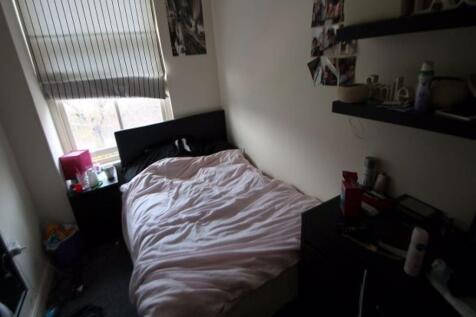 A cozy student bedroom featuring a neatly made ...