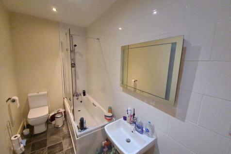 A well-maintained bathroom featuring a bathtub,...