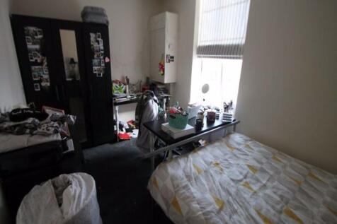 A modest bedroom with a single bed and a window...