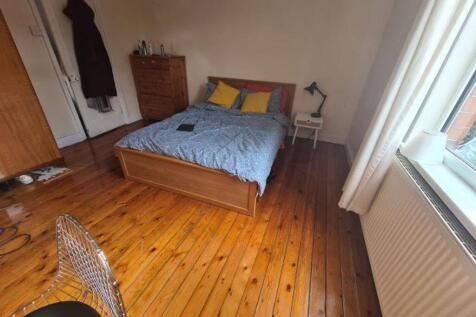 A spacious master bedroom featuring a comfortab...