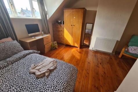 A cozy bedroom featuring a double bed with bedd...