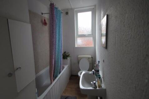 A clean and functional bathroom with a bathtub,...