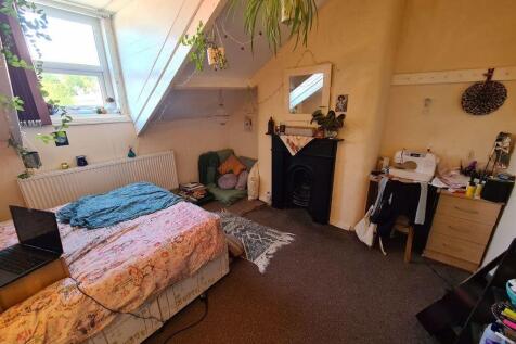 A cozy bedroom featuring a double bed, a window...
