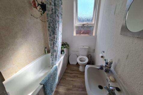 A well-maintained bathroom featuring a bathtub,...