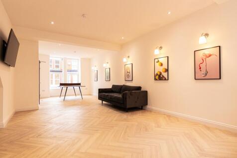 A spacious, well-lit living room featuring a co...