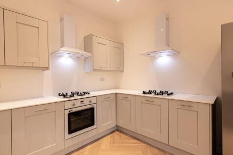 Modern, bright kitchen with sleek white cabinet...