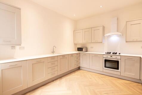 Bright and modern kitchen with ample cabinets, ...