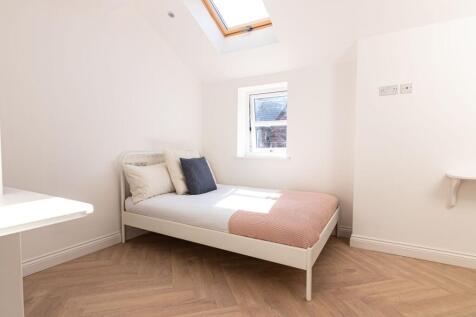 Bright and stylish bedroom featuring a clean wh...