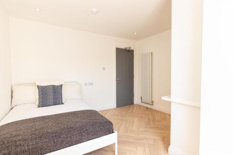 A bright and tidy double bedroom featuring a co...