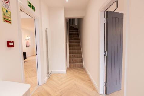 Bright, modern entrance hallway with chevron wo...
