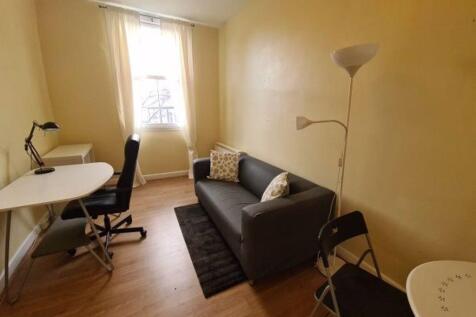 A cozy single bedroom featuring a compact works...