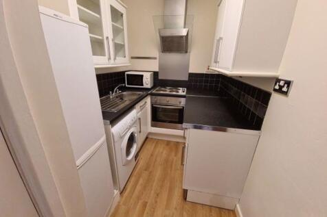 A compact, modern kitchen featuring integrated ...