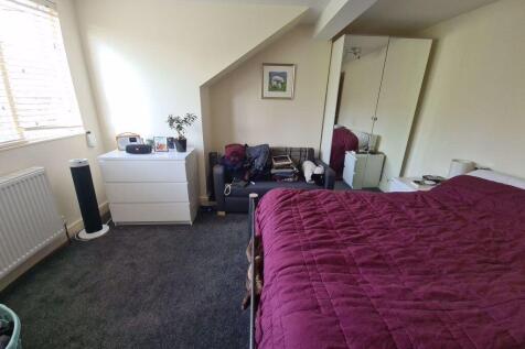 A spacious master bedroom featuring a large bed...