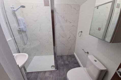 A modern bathroom featuring a walk-in shower wi...