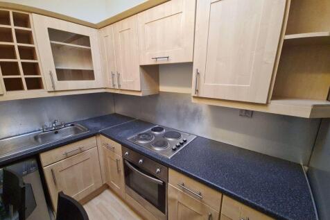 A modern kitchen featuring ample wooden cabinet...