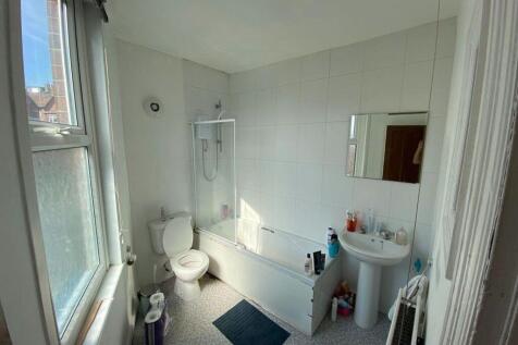 Bright and clean bathroom featuring a bathtub, ...