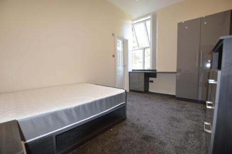 A spacious, well-lit bedroom featuring a large ...