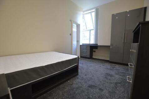 A bright and tidy student bedroom featuring a s...