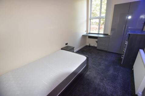 A tidy and well-lit bedroom featuring a single ...