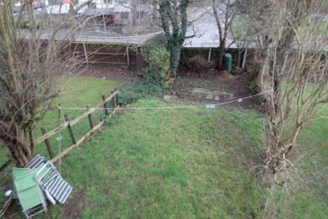 A well-maintained garden with lush grass, surro...