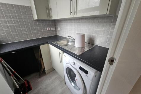 Compact and tidy kitchen featuring modern cabin...