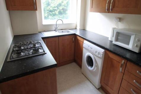 A well-maintained kitchen with wooden cabinets,...